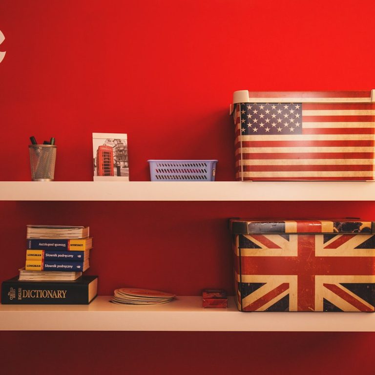 Regal mit amerikanischer und britischer Flagge, Büchern und Schreibutensilien.