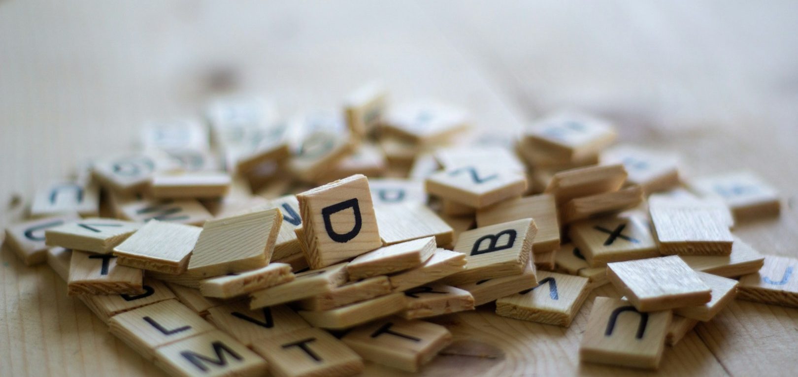 Holzbuchstaben-Durcheinander Ein Haufen Holzbuchstaben mit schwarzen Buchstaben auf einem Tisch.