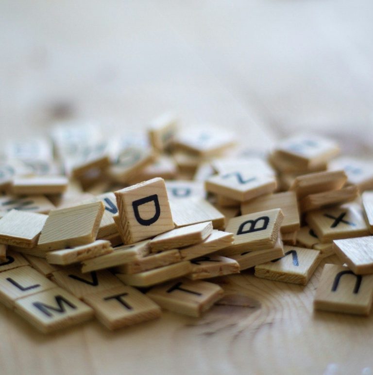 Buchstaben-Durcheinander Holzbuchstaben liegen verstreut auf einem Tisch.