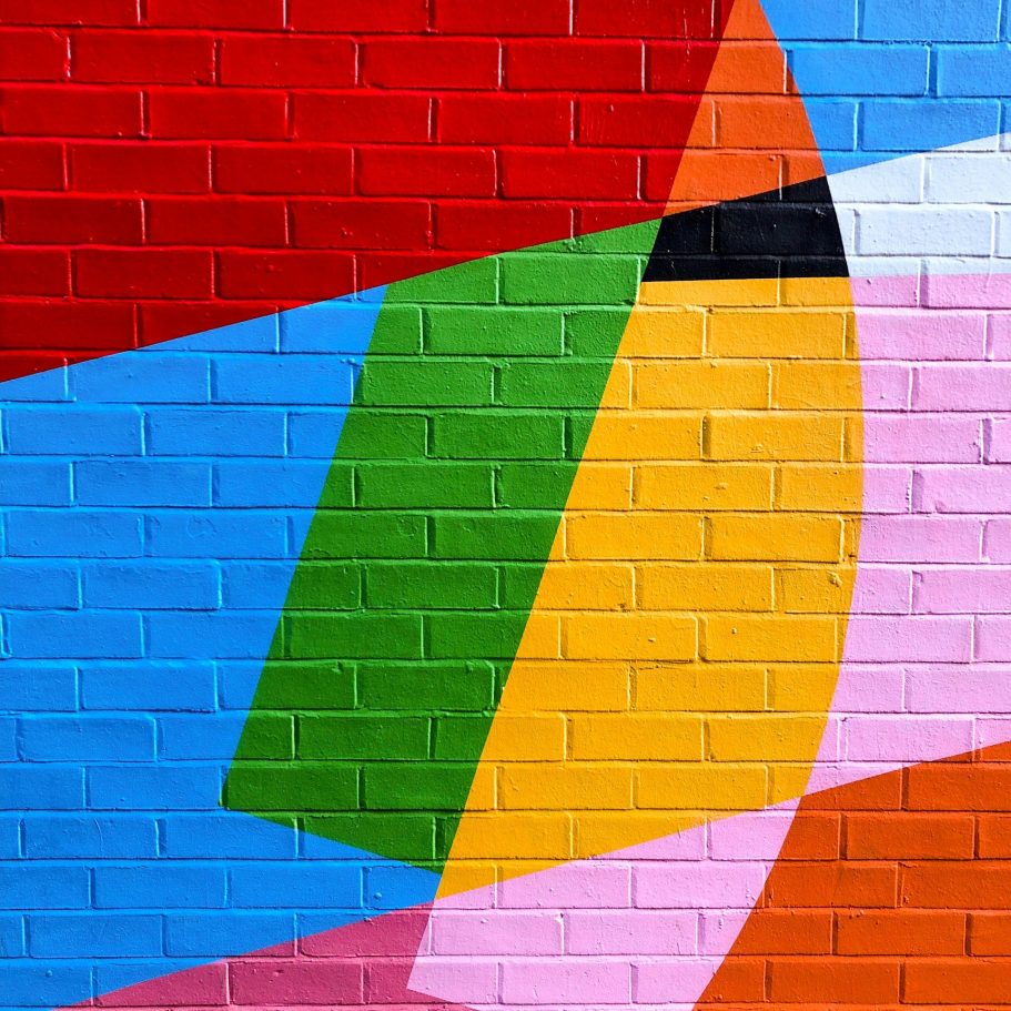Ziegelwand, die mit bunten geometrischen Formen bemalt ist
